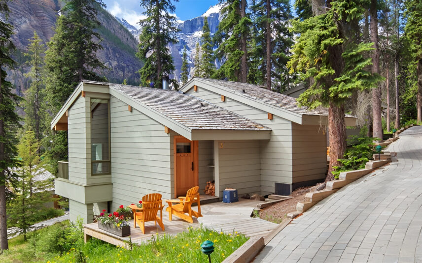 Image of yellow chairs sat in front of Moraine Lake lodge cabins overlooking the lake.