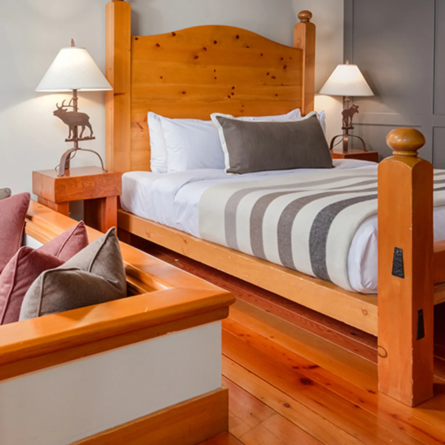 Cozy cabin interior at Moraine Lake with wooden beams, a double bed dressed in earthy-toned linens, a
